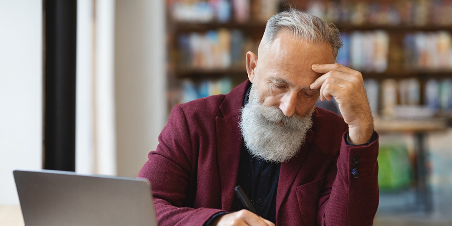 photo of a man looking at a computer wondering