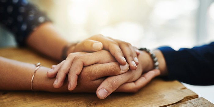 hands embracing to provide comfort after death of loved one