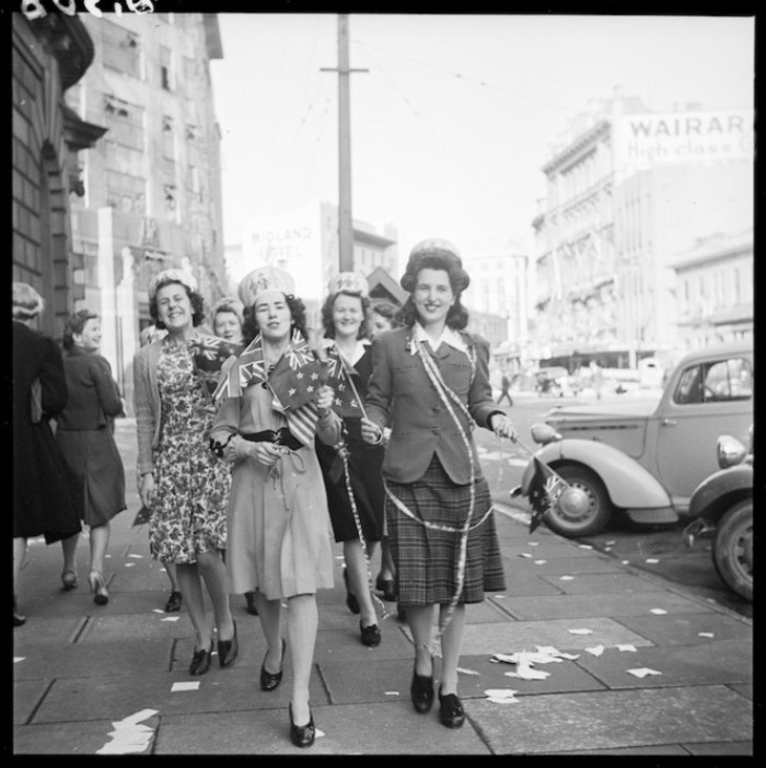 A group of women celebrating Victory in Europe walk past the Public Trust Office on Lambton Quay, Wellington, on 8 May 1945. 1/4-001508-F Alexander Turnbull Library